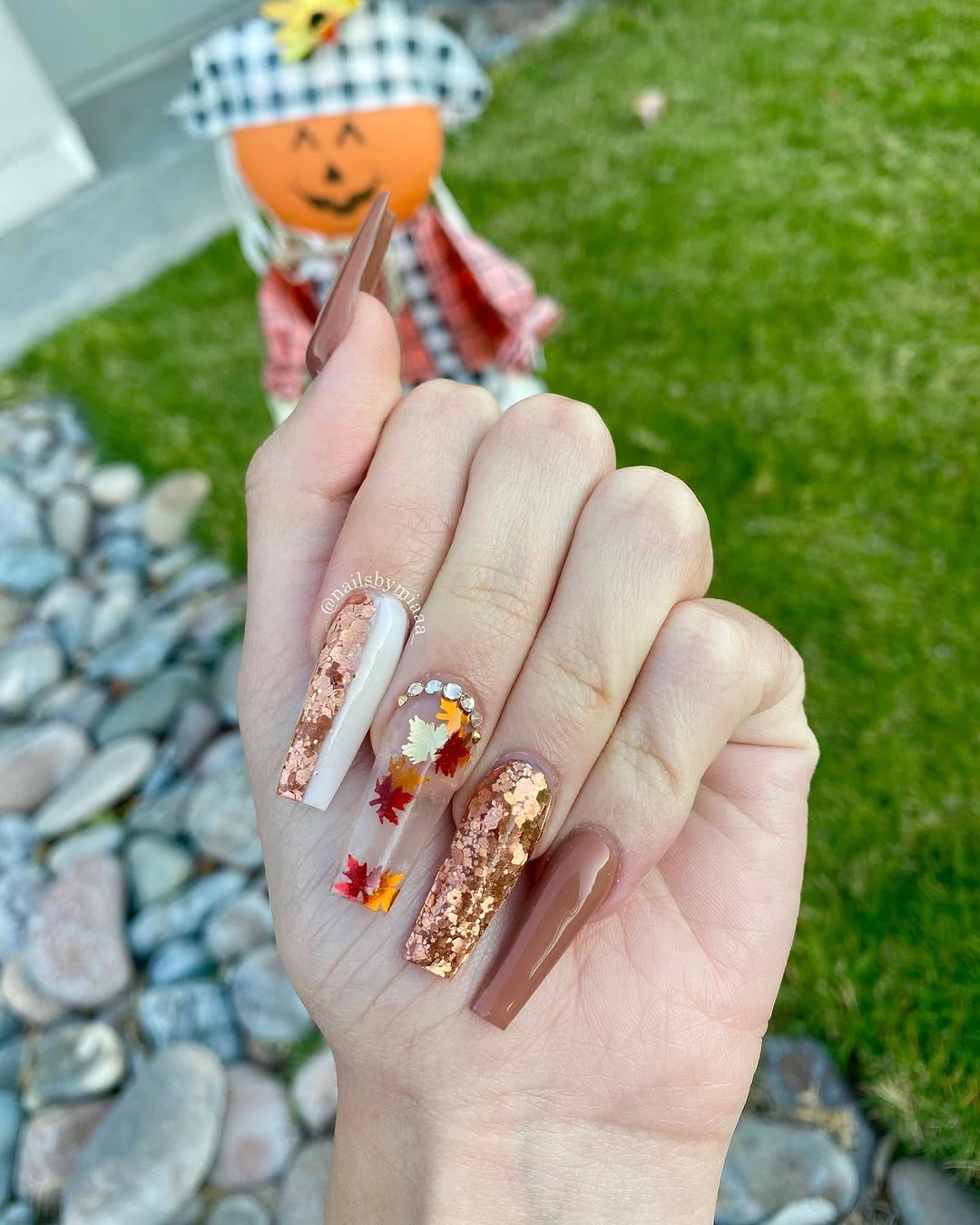 Long coffin nails with translucent bases and warm autumn clusters
