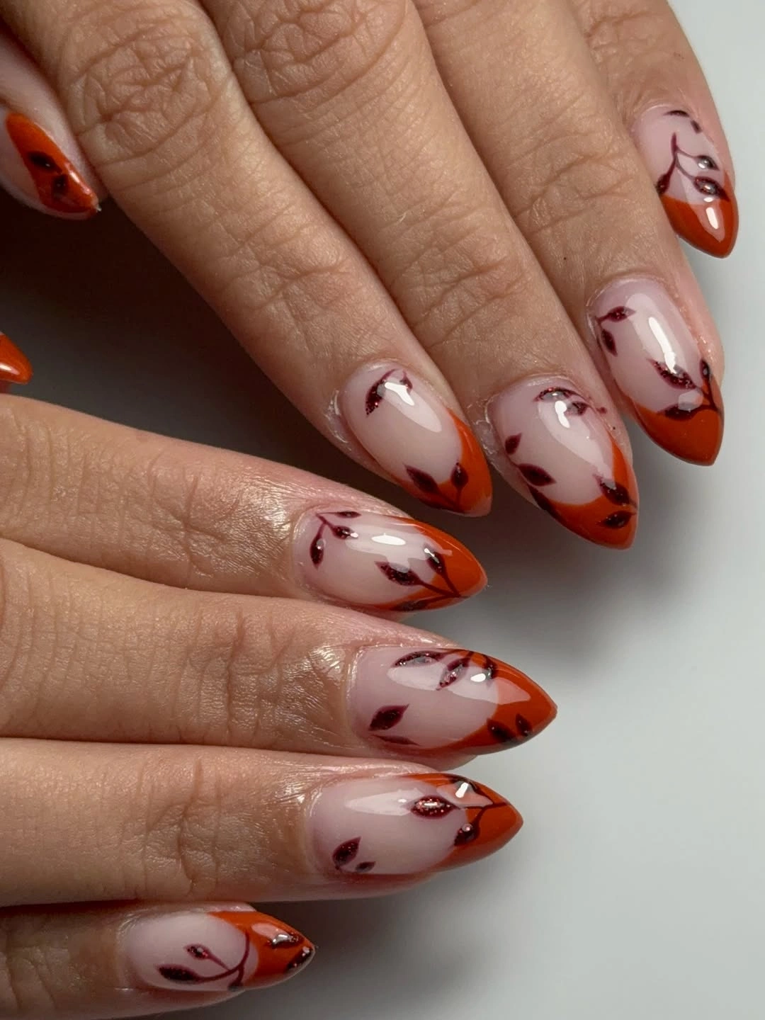 Long almond milky nude nails with dark curved autumn tips