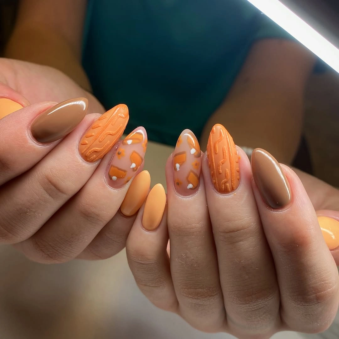 Orange almond nails with textured seasonal accent details