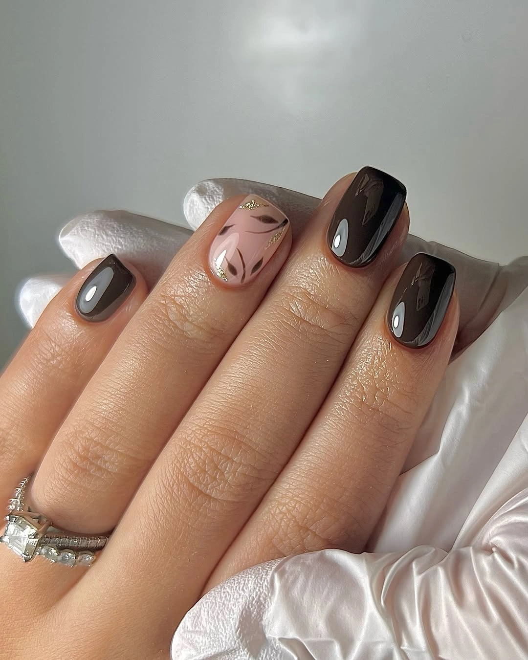Charcoal almond nails with pale accents and curved black lines