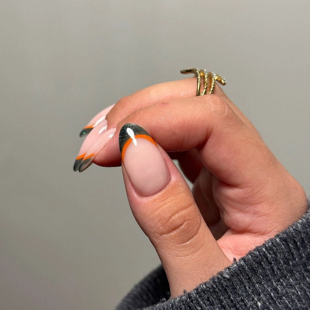 Medium pale almond nails with orange black contour lines