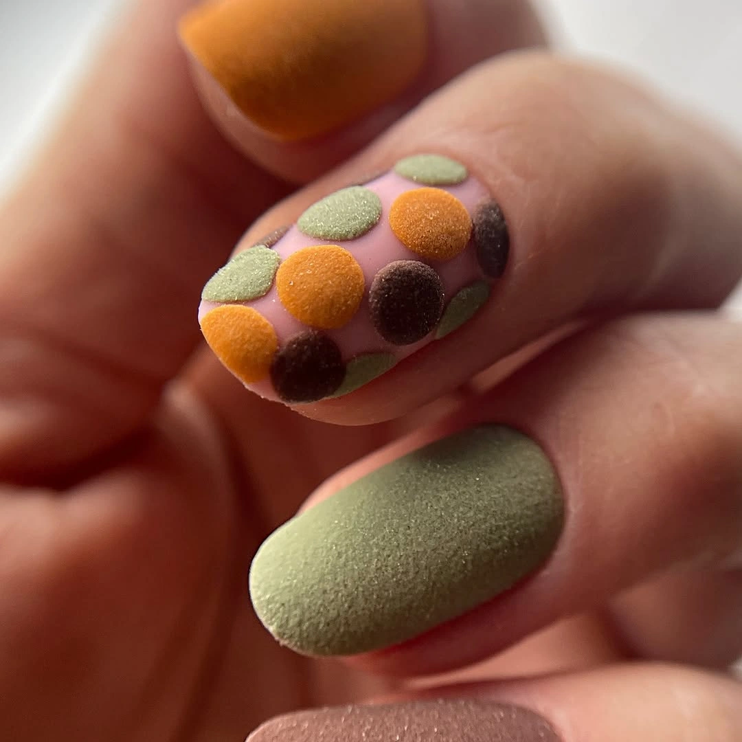 Short olive nails with raised orange mustard and brown dots