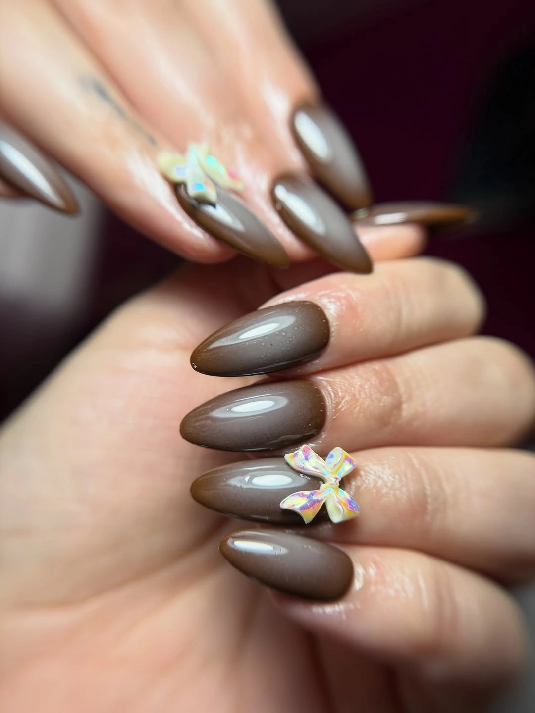 Medium taupe almond nails with one iridescent floral accent