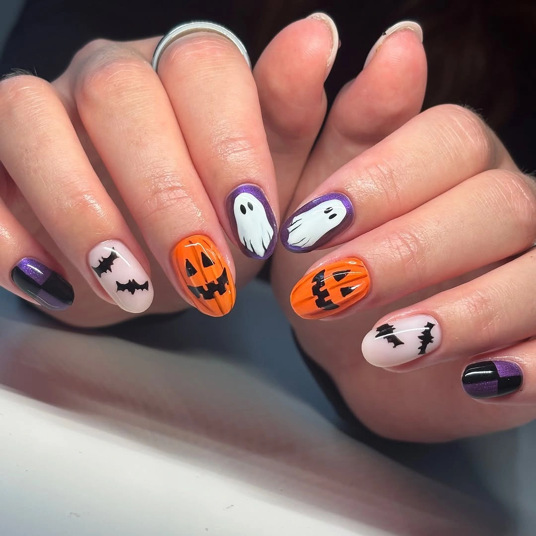 Short orange pumpkin nails with white ghost and black accents