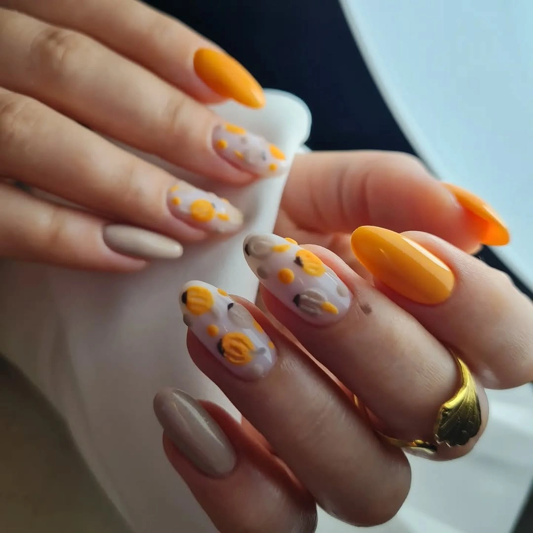 Long square nails with orange tips and tiny pumpkin details