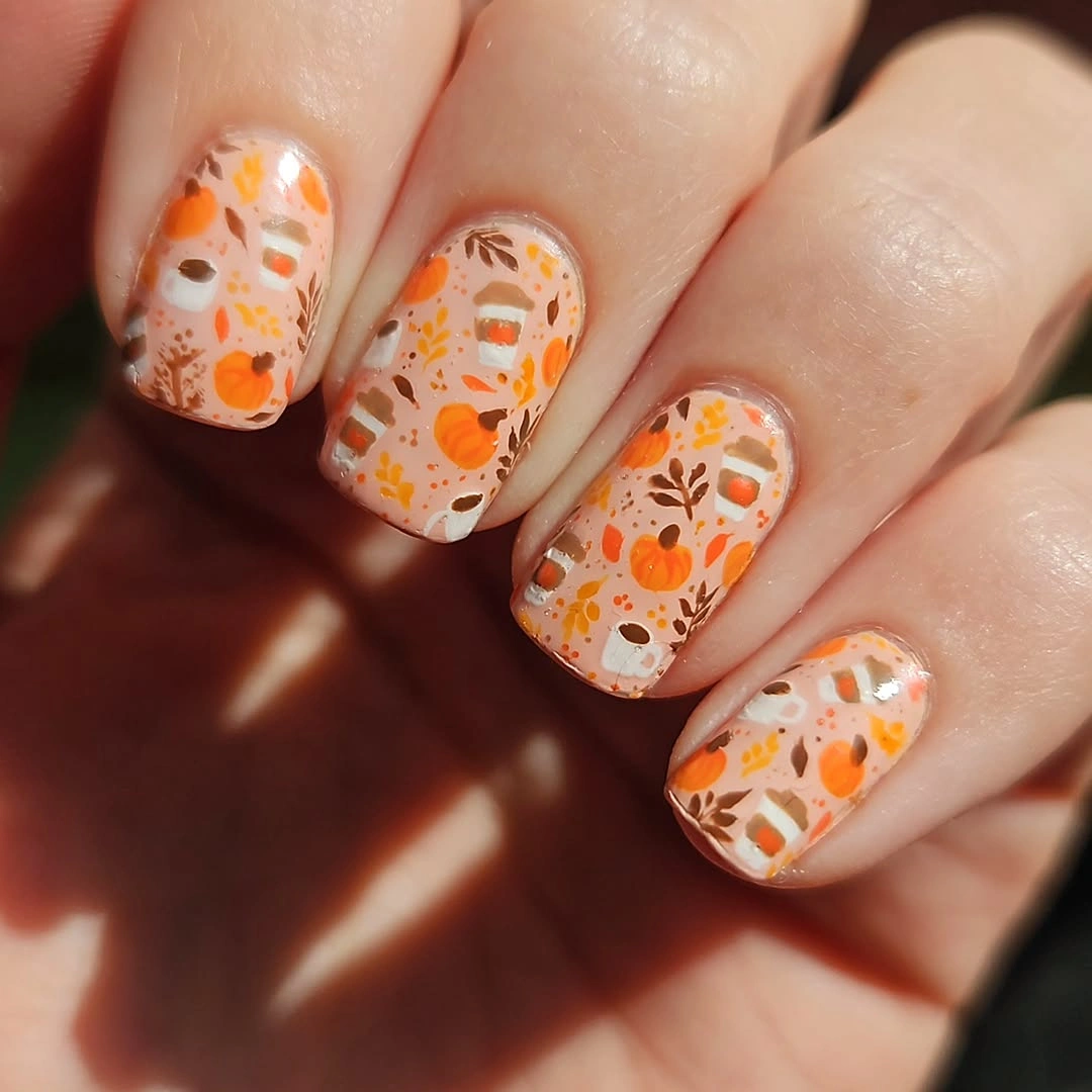 White square nails with scattered orange pumpkin motifs