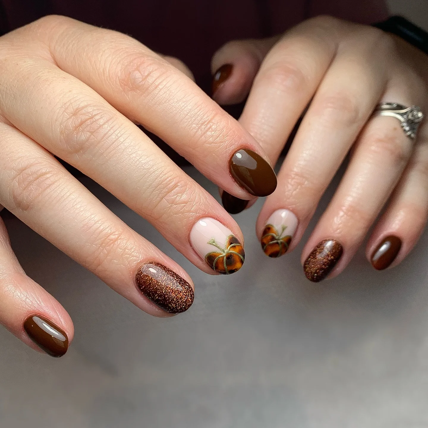 Short brown oval nails with nude pumpkin and fall accents