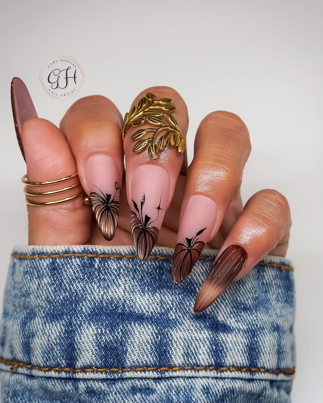 Long nude nails with orange florals black webs and gold detail