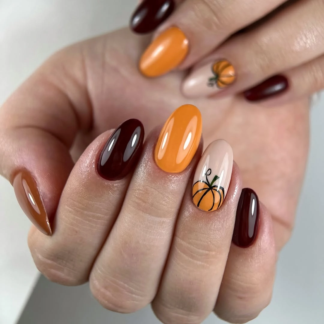 Chocolate brown and orange almond nails with one pumpkin accent