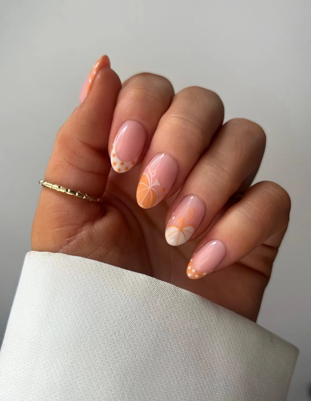 Blush almond nails with sparse orange autumn accents