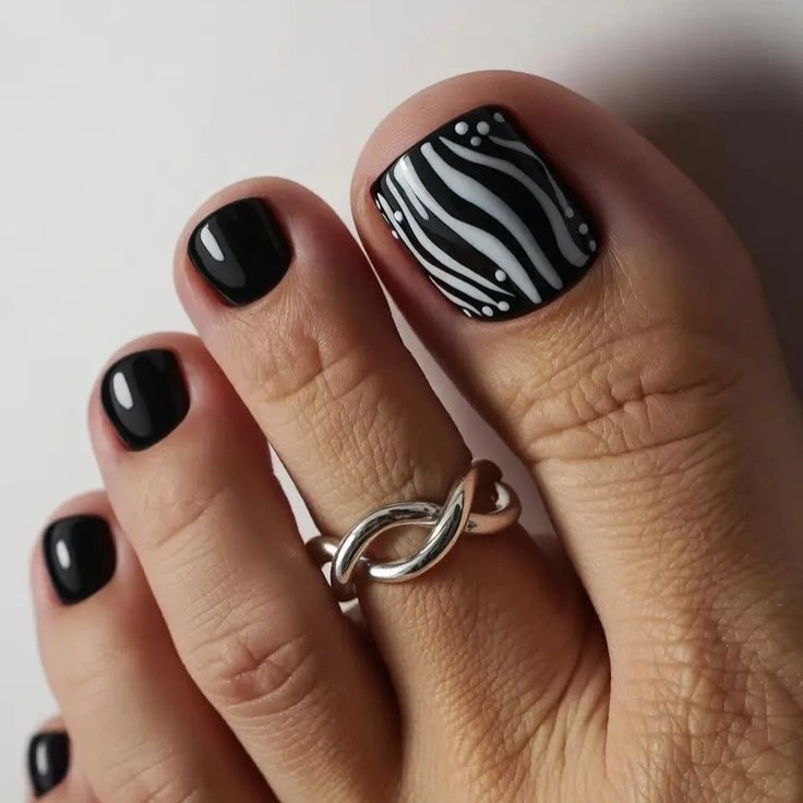 Black pedicure with white zebra like big toe lines