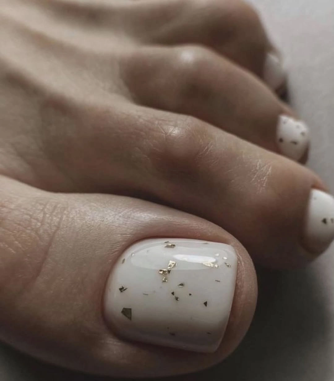 Creamy white short toenails with tiny flecks