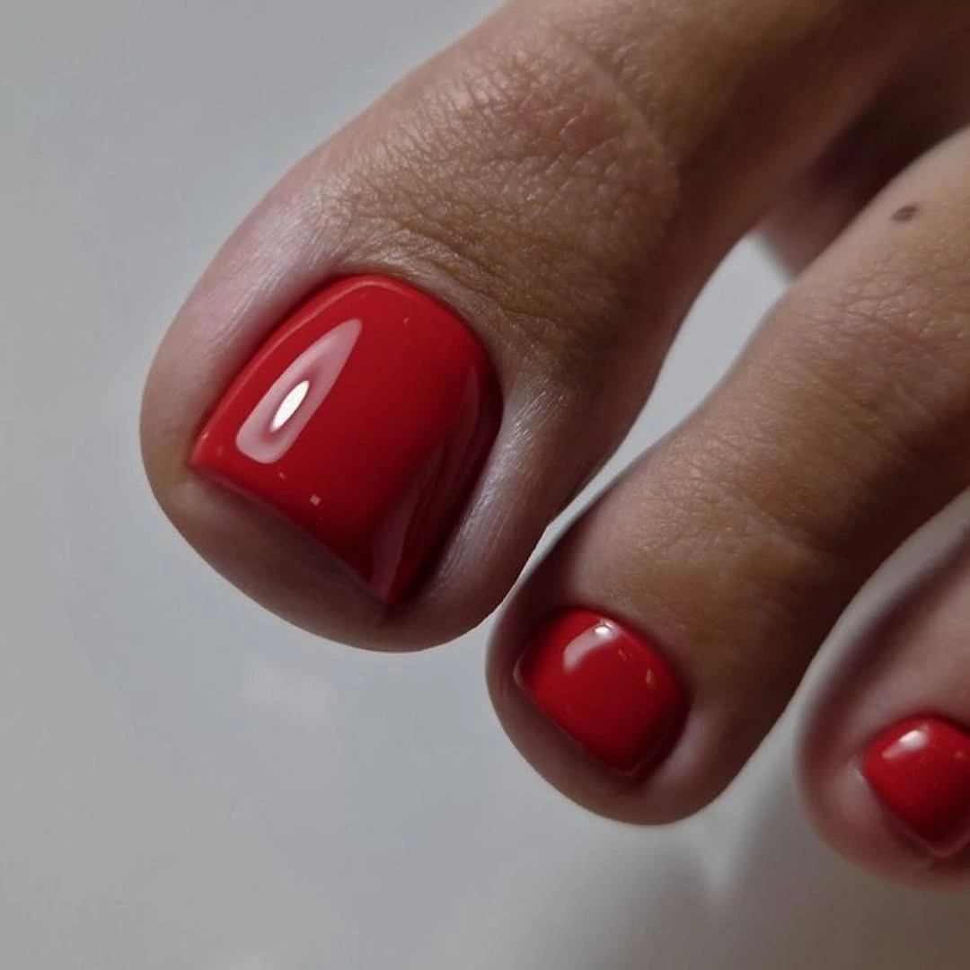 Classic glossy red pedicure on very short toenails
