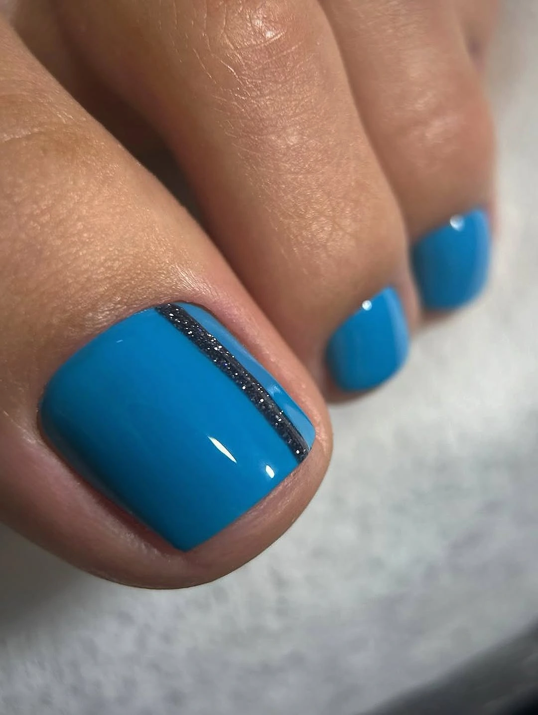 Teal blue toenails with slim dark side stripe