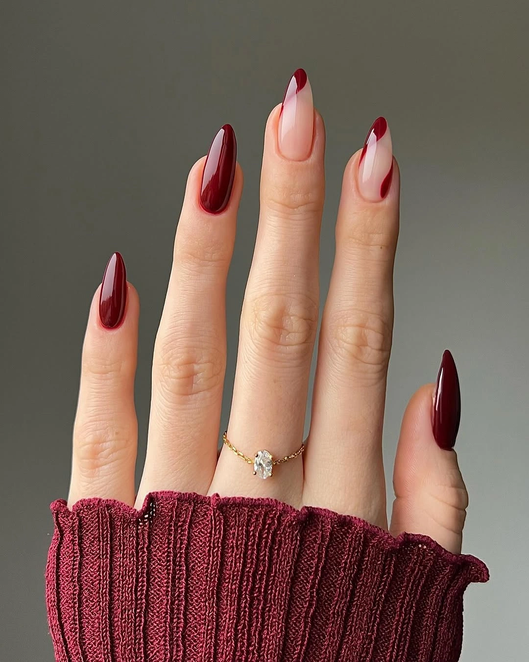 Wine red almond nails with nude curved accents