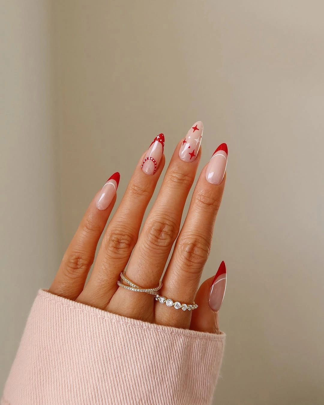Almond nude nails with red French tips and stars