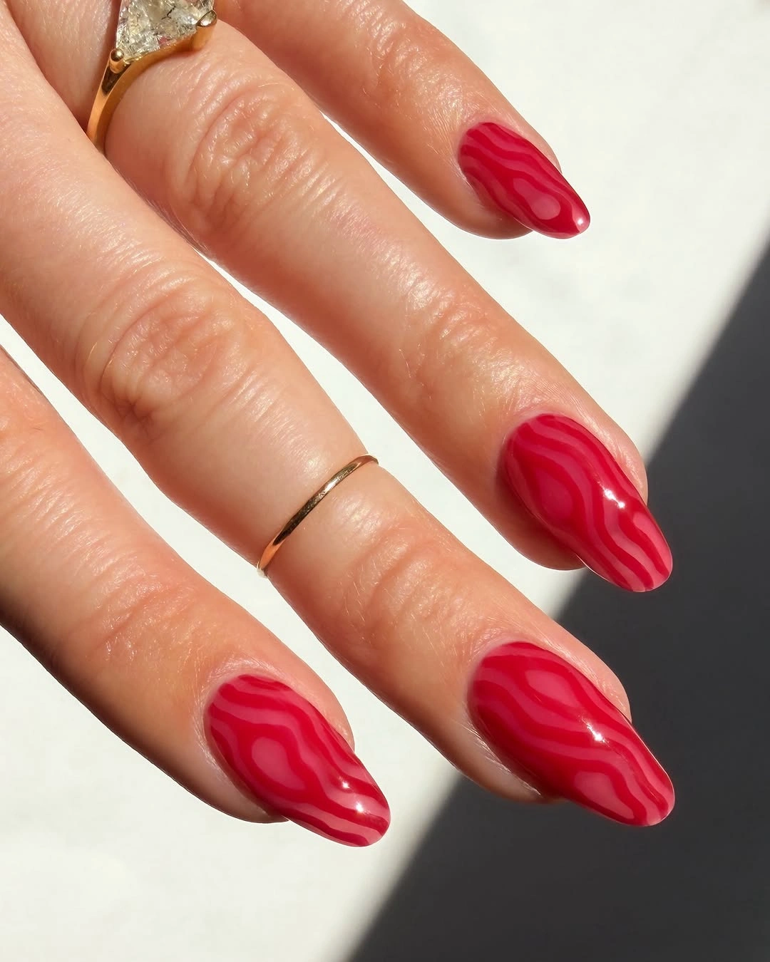 Almond red nails with darker wavy line art