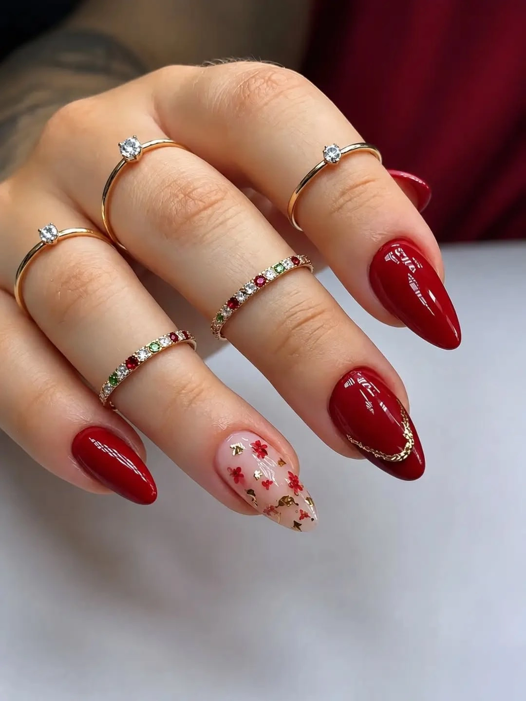 Deep red almond nails with pale floral accent