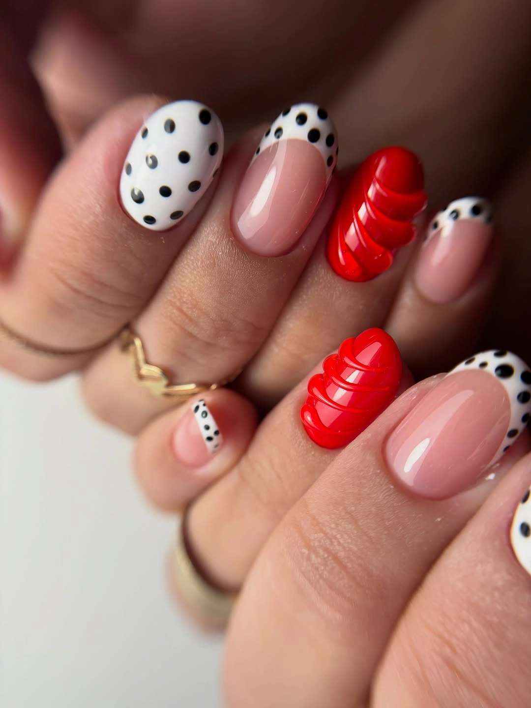Pale nails with red curved stripes and black dots