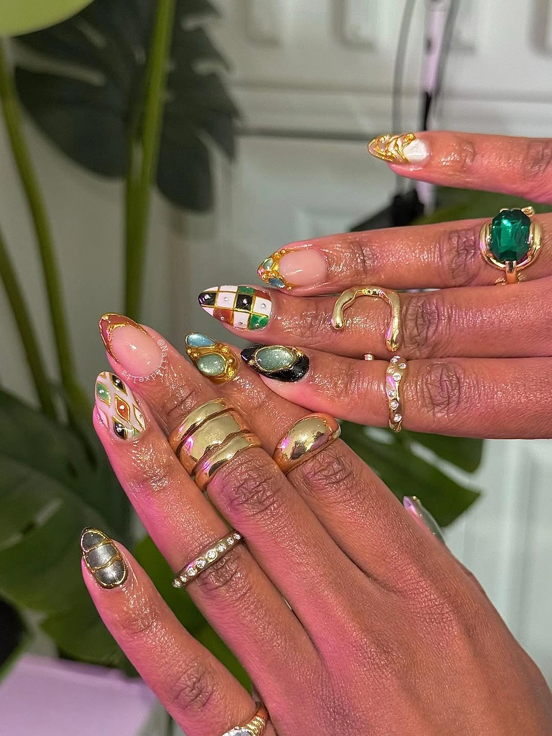 Bright pink almond nails with colorful gems and raised details