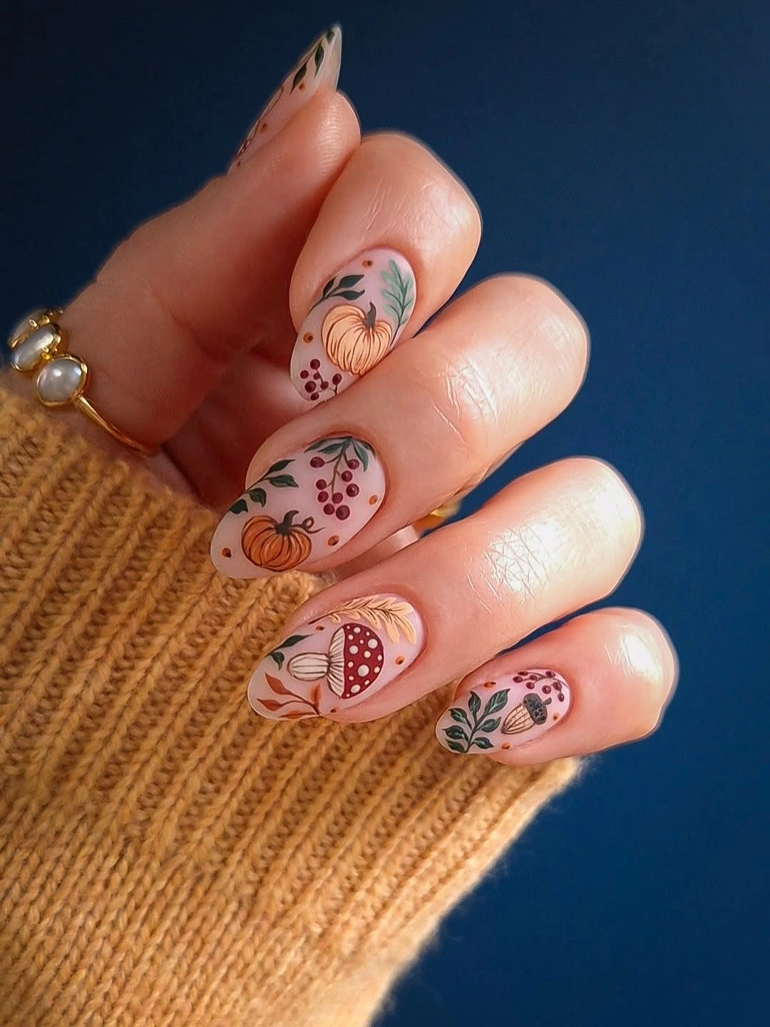 Dusty pink almond nails with tiny warm autumn motifs