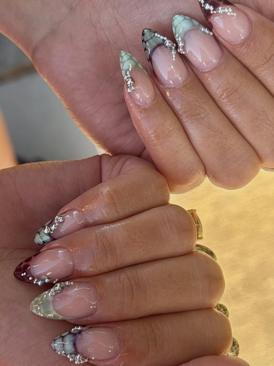 Sheer pink almond nails with silver clustered tips
