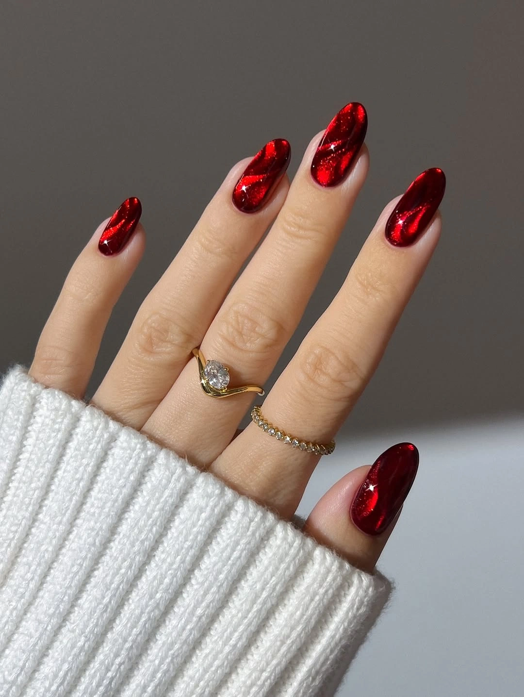 Reflective cherry red polish on compact almond nails