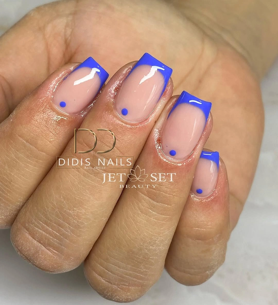 Short nude nails with electric-blue French outlines