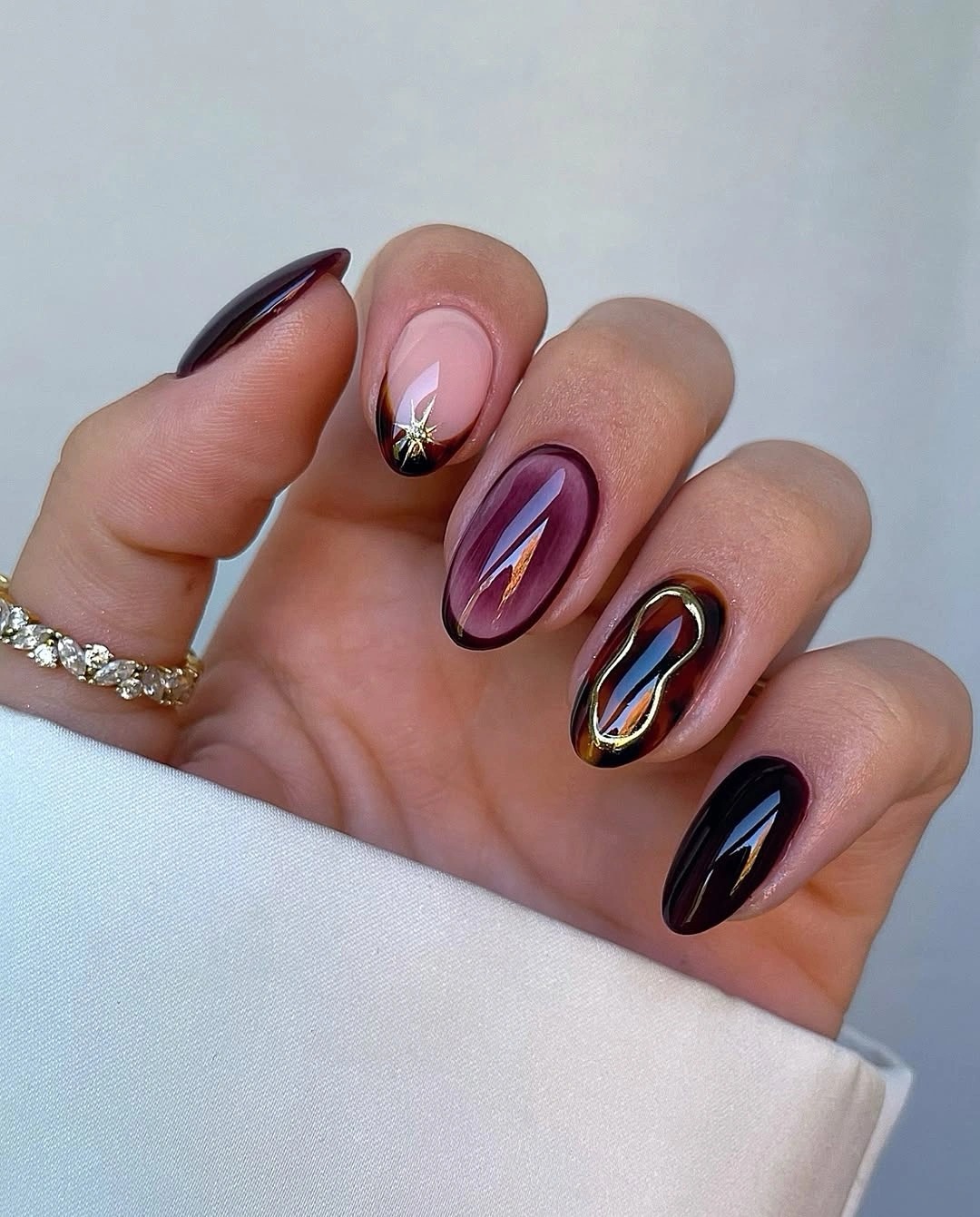 dark jewel tone nails with gold abstract line art