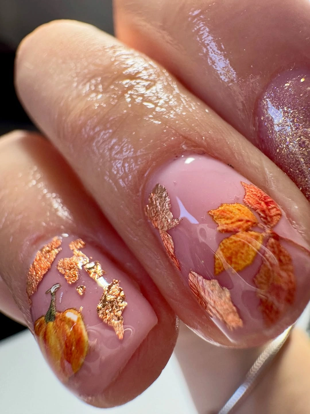 sheer short nails with tiny pumpkin leaves and copper foil