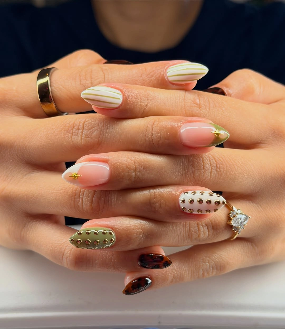 olive striped nails with studs and tortoise accents