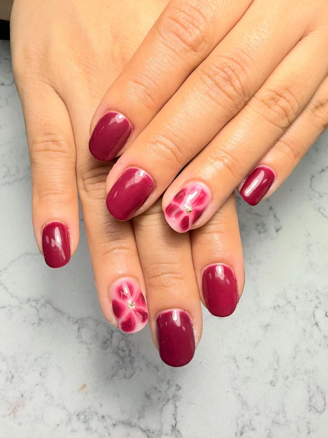 cranberry short nails with soft pink flower accents