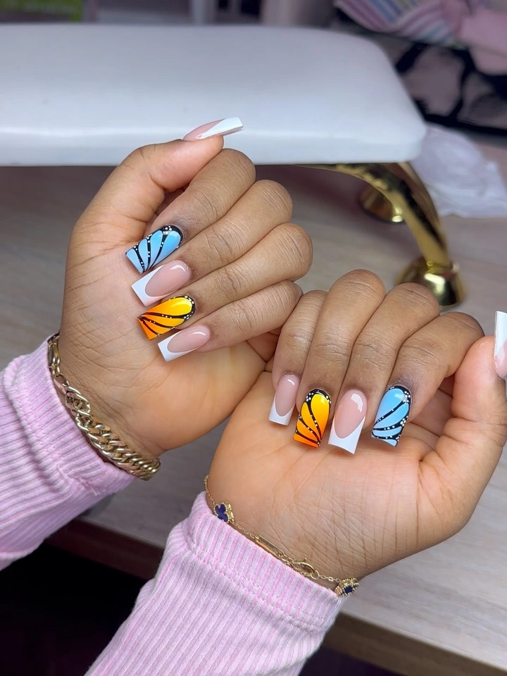 Long white and pink square nails with blue yellow butterfly motifs
