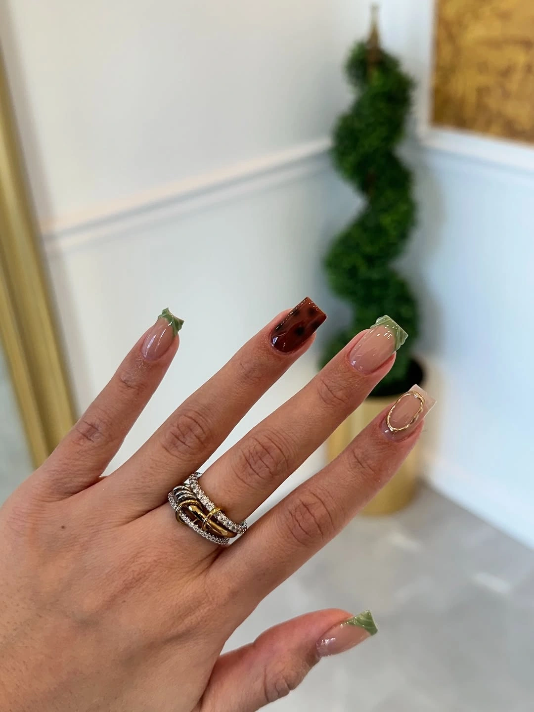 Square nails with green burgundy tips and small orange red accents
