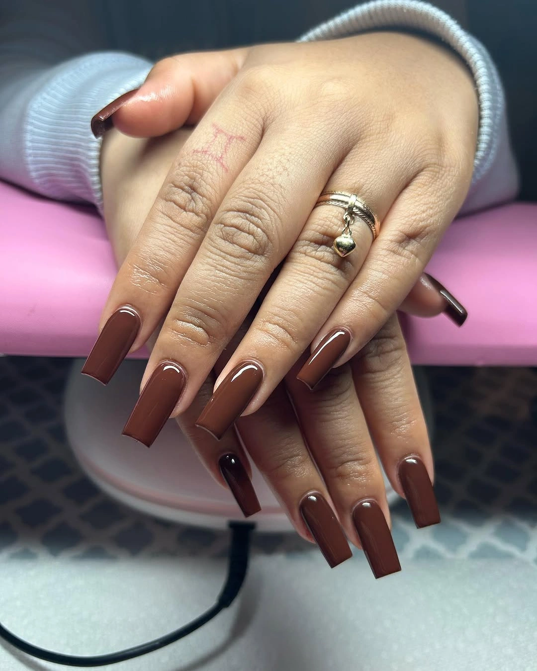 Long brown square nails with pale curved accent lines