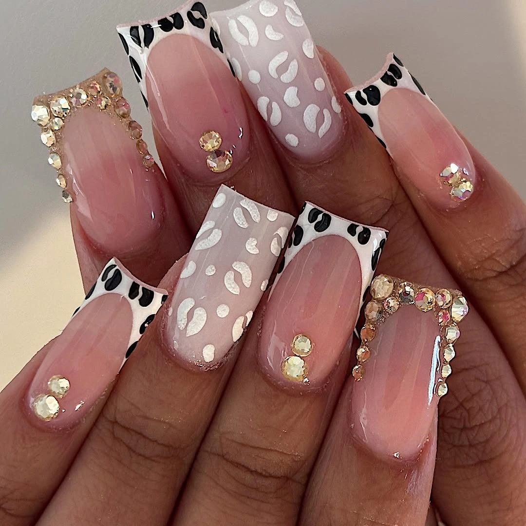 Long pink square nails with white patterned tips and small accents