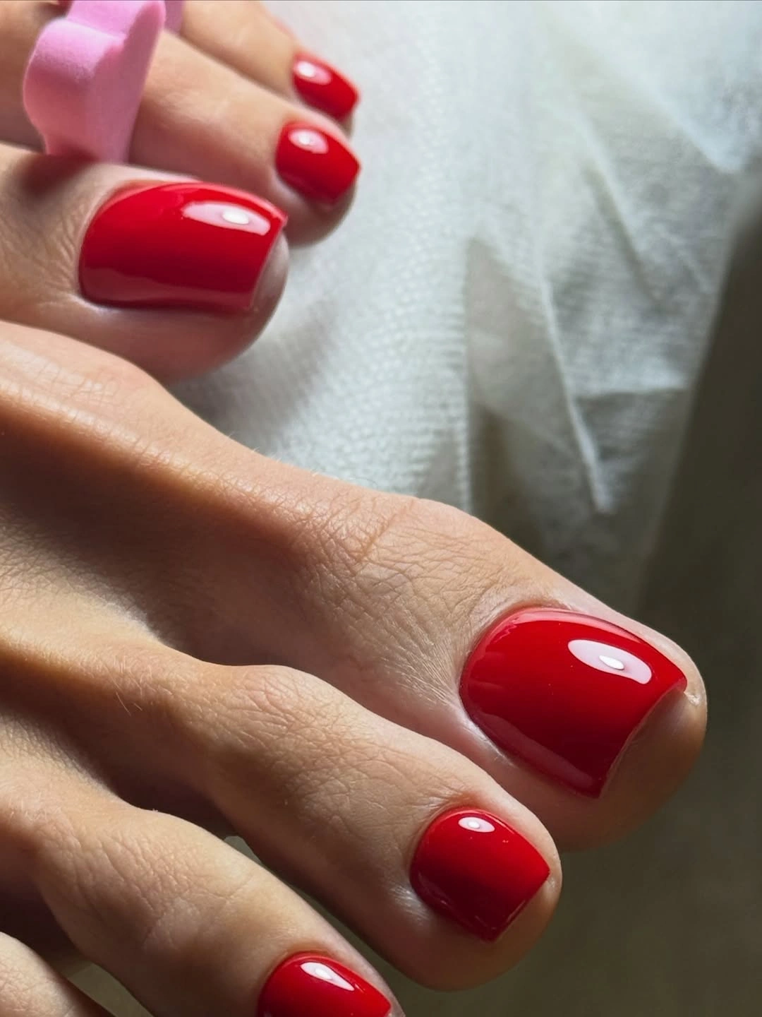 Saturated glossy cherry red short square toenails