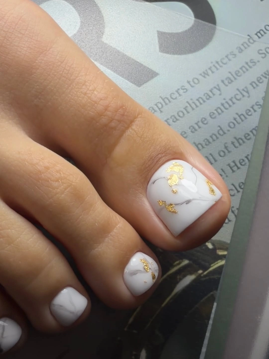 White big toe with tiny yellow flower accents on pale toes
