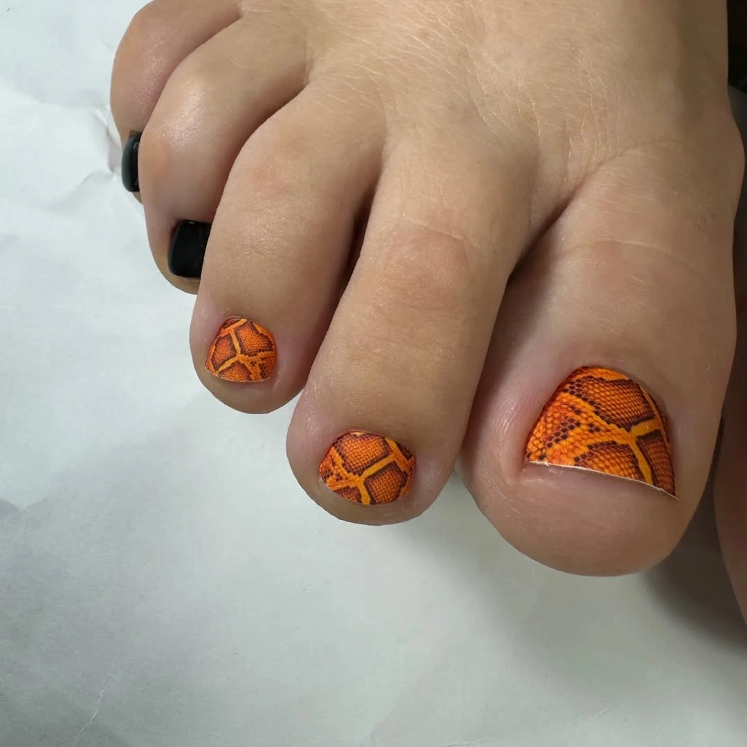 Terracotta toe nails with darker geometric accent motifs