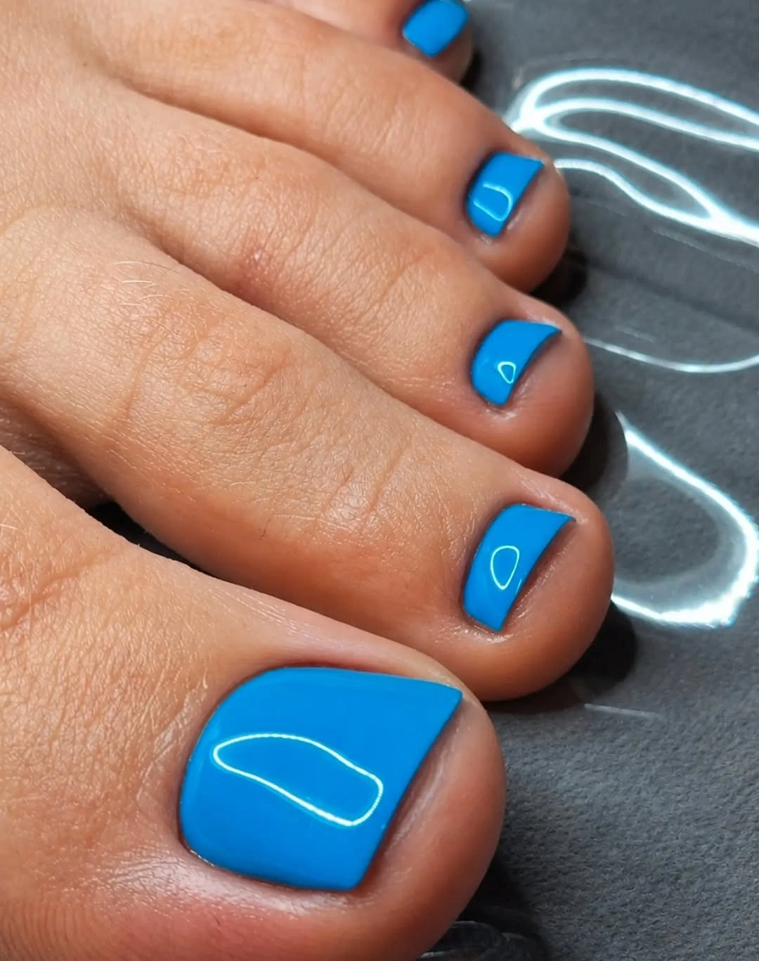 Electric blue square toenails with white outline accents