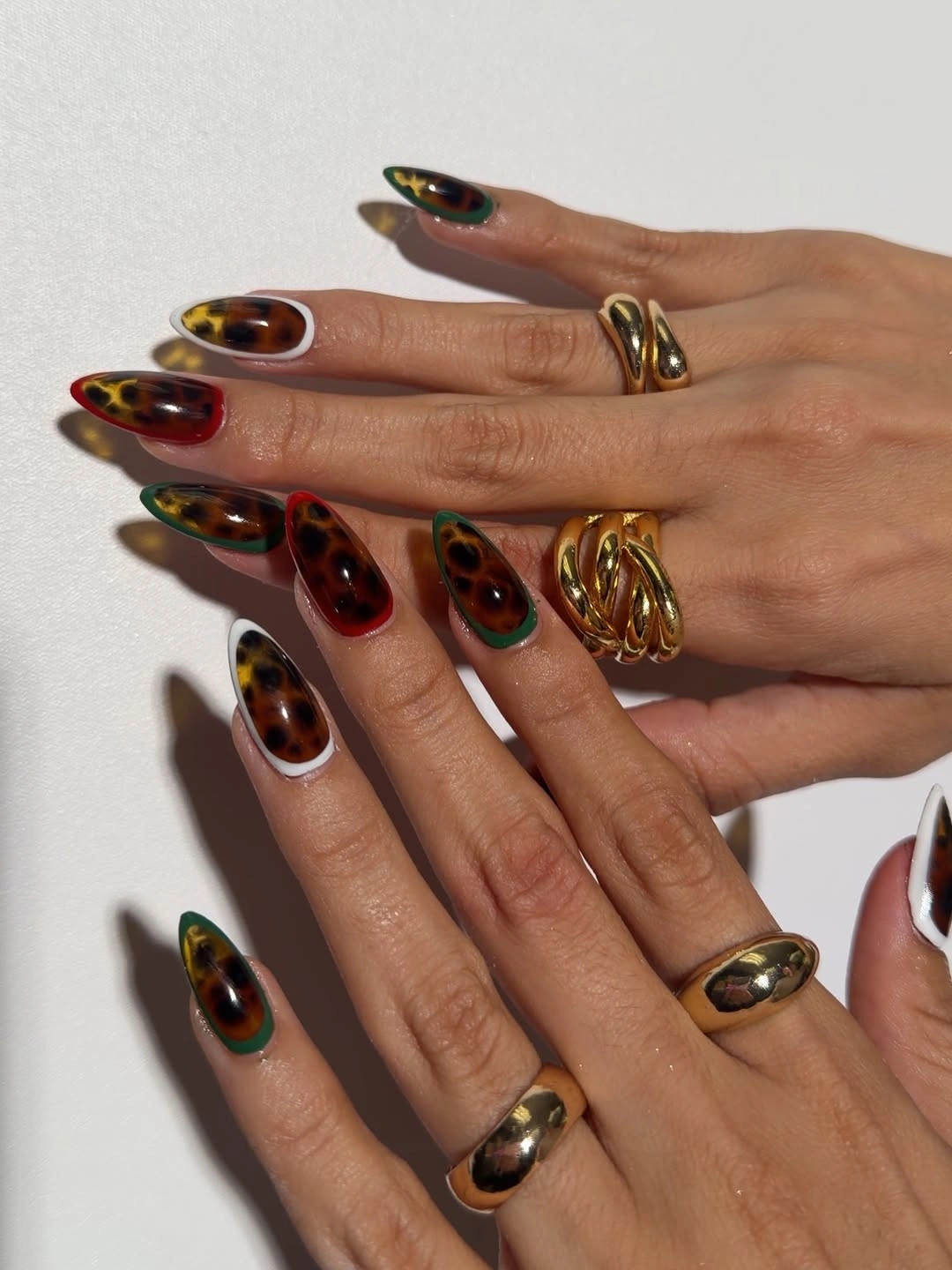 Dark tortoiseshell almond nails with selective gold accents