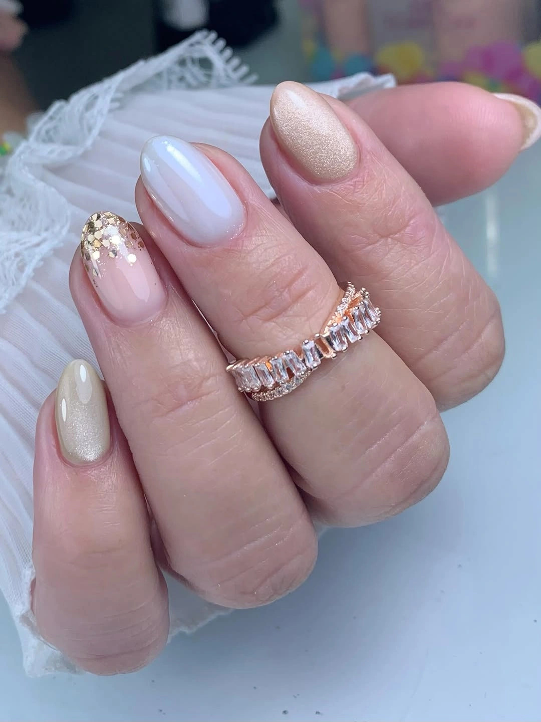 Pearly pink rounded nails with one glittery accent