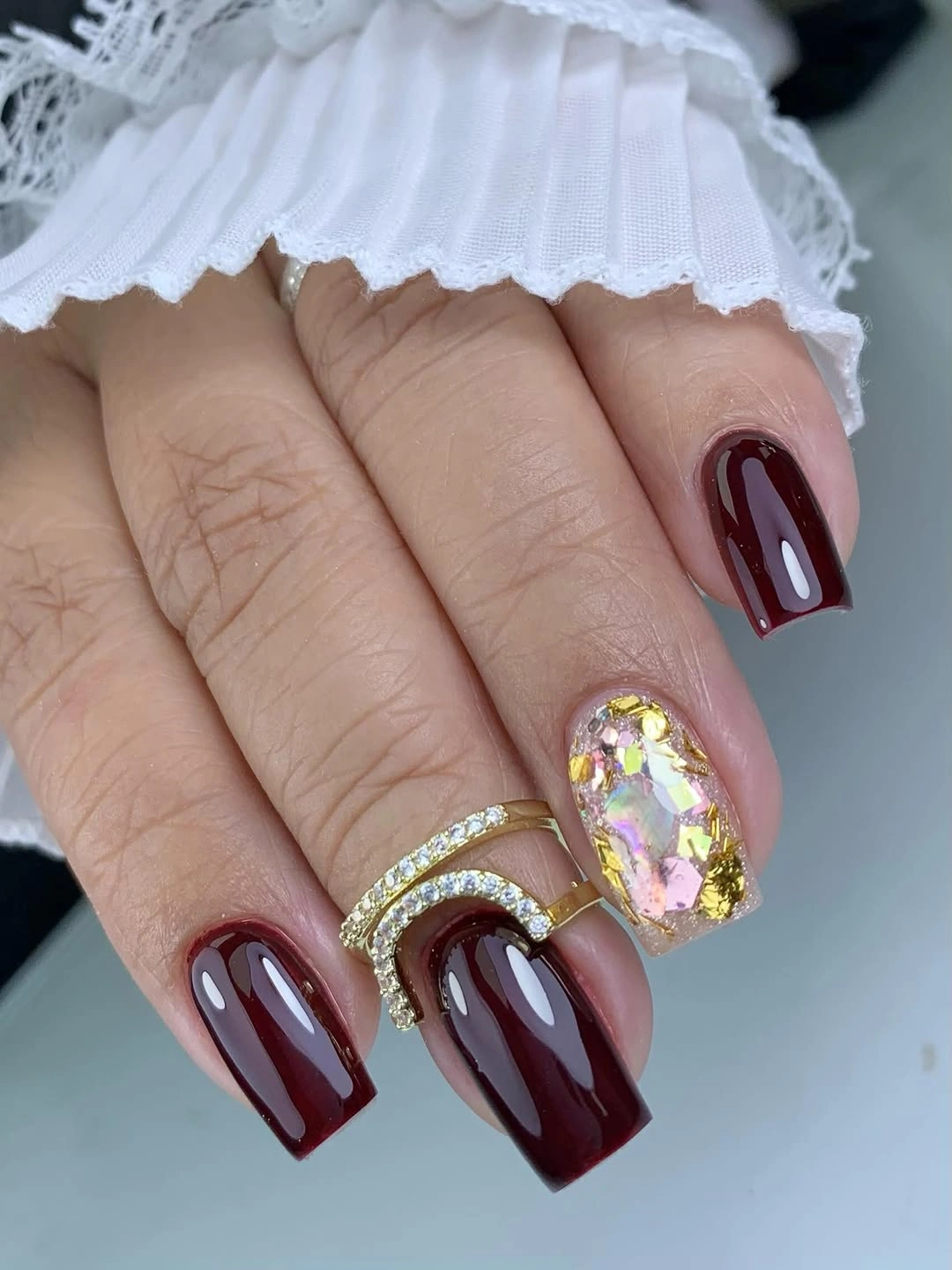 Deep burgundy coffin nails with one ornate pale accent
