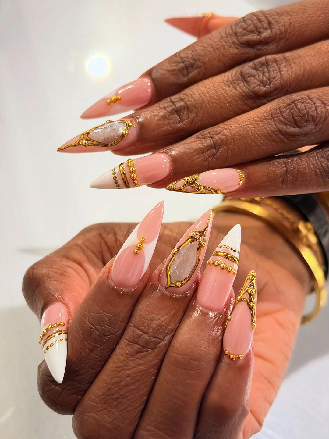 Long peach stiletto nails with white and gold edge details
