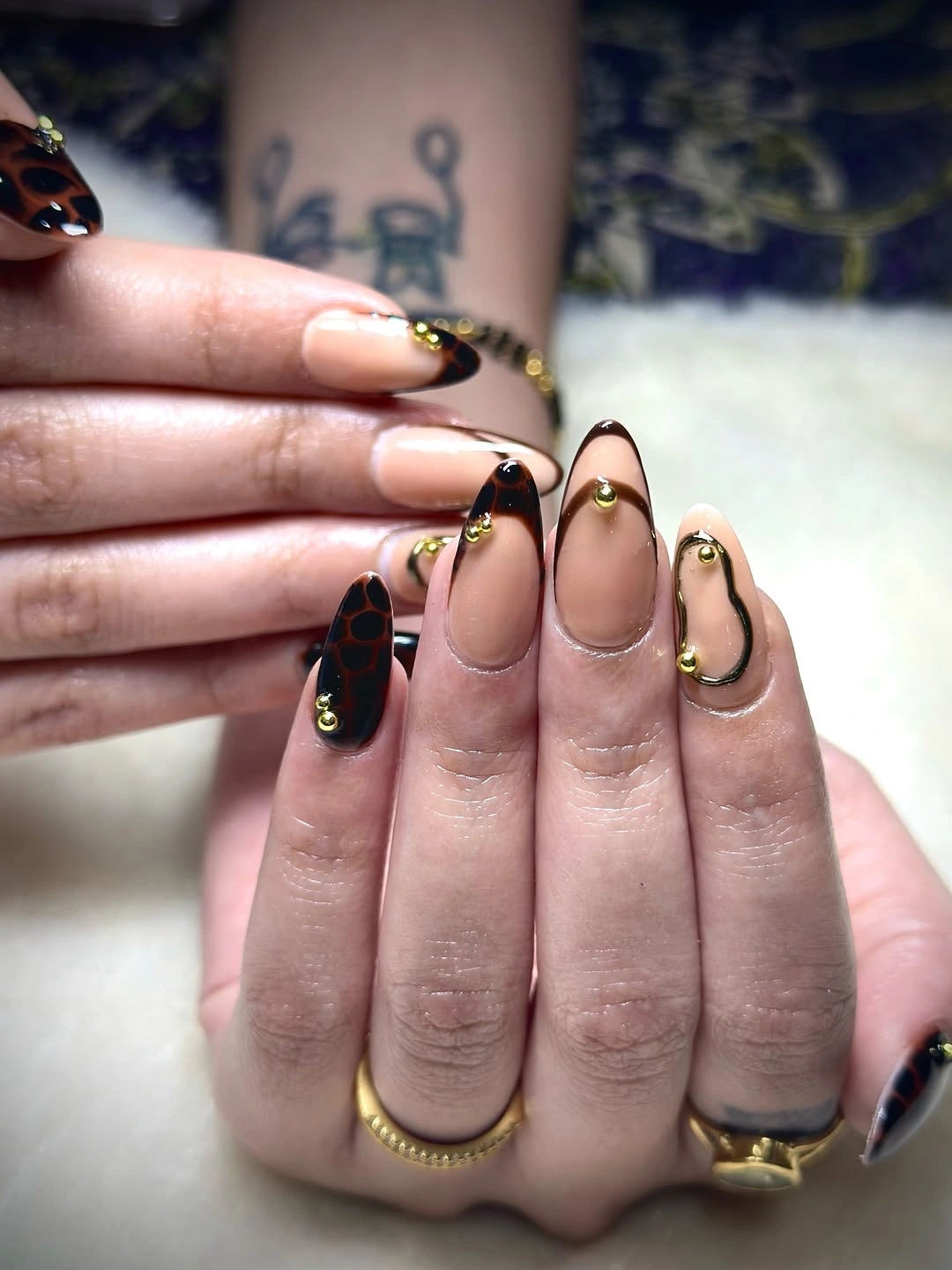 Long almond nails with black French tips and thin gold outlines