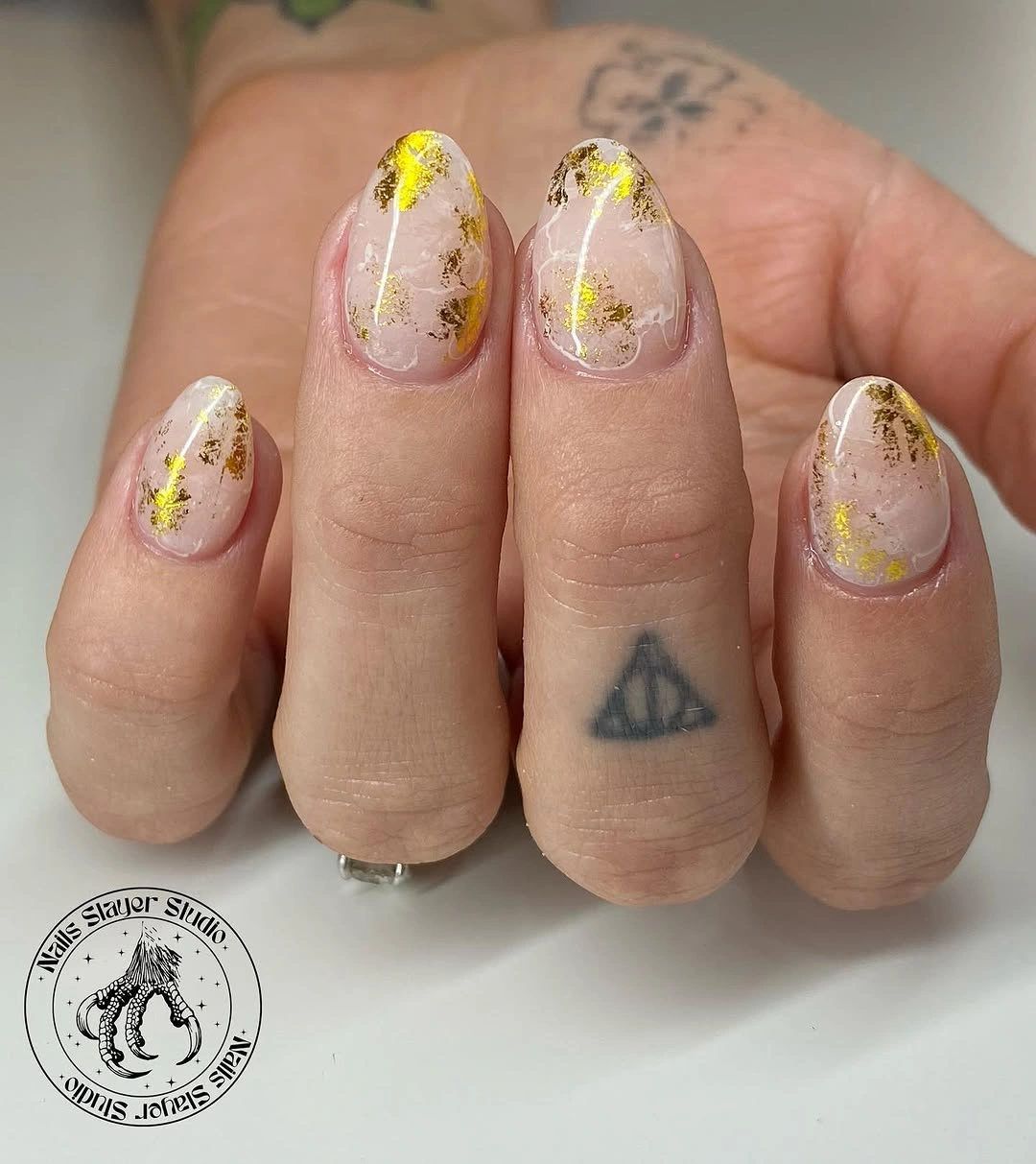Short rounded wedding nails with pale marbling and gold foil