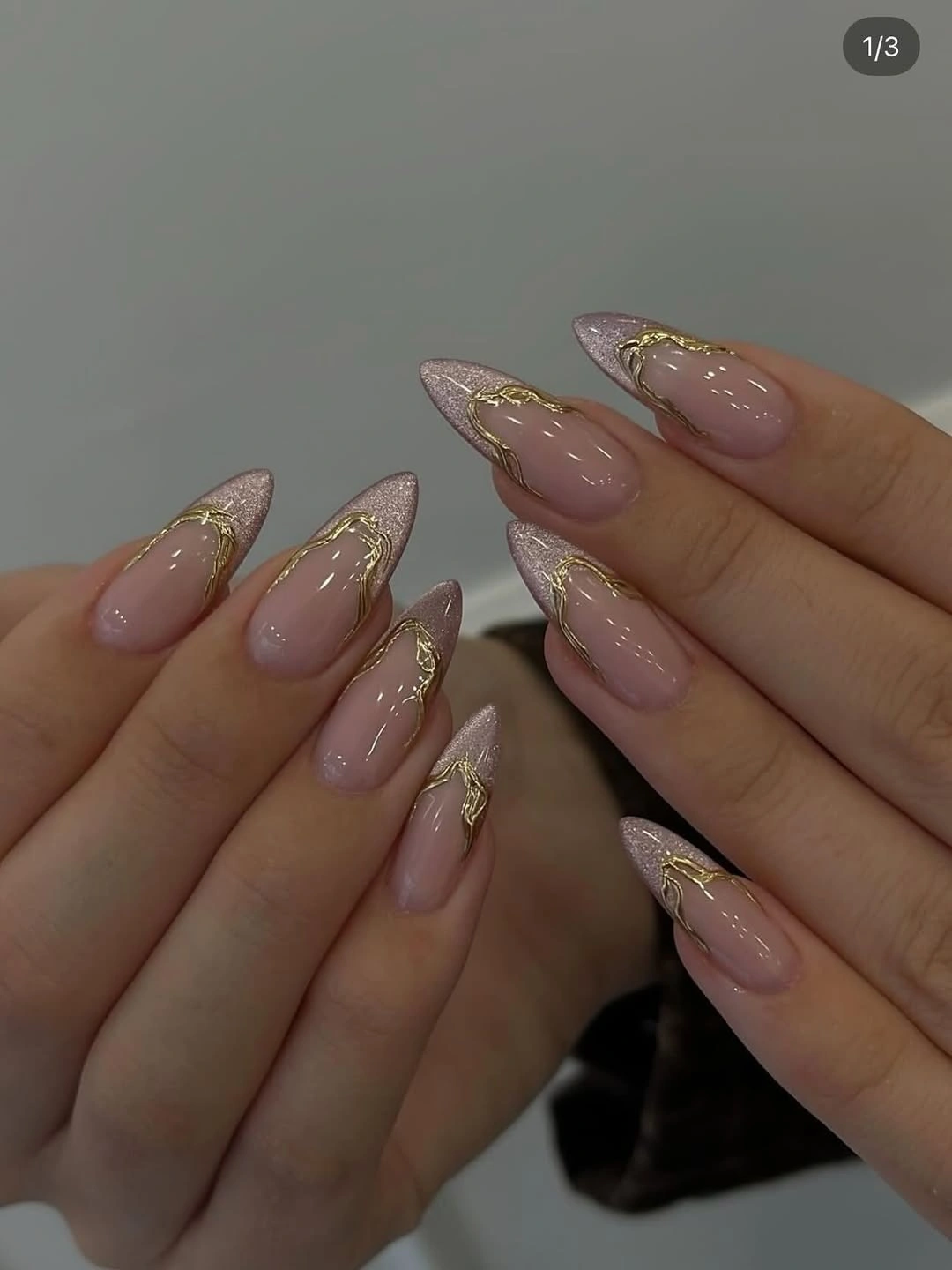 Sheer pink almond nails with champagne flecks and fine gold edges