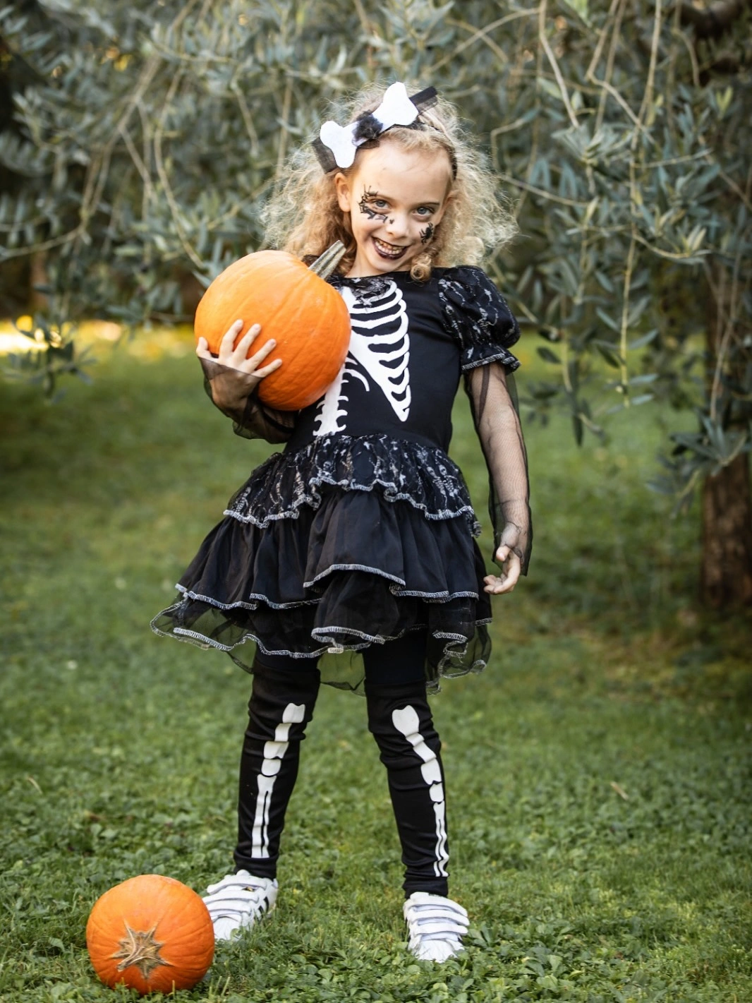 Kids black ruffled skeleton dress with striped knee socks white bow and black sneakers