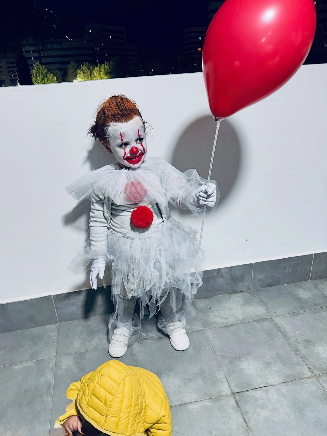 Kids white clown Halloween costume with red pom-poms red wig sneakers and red balloon