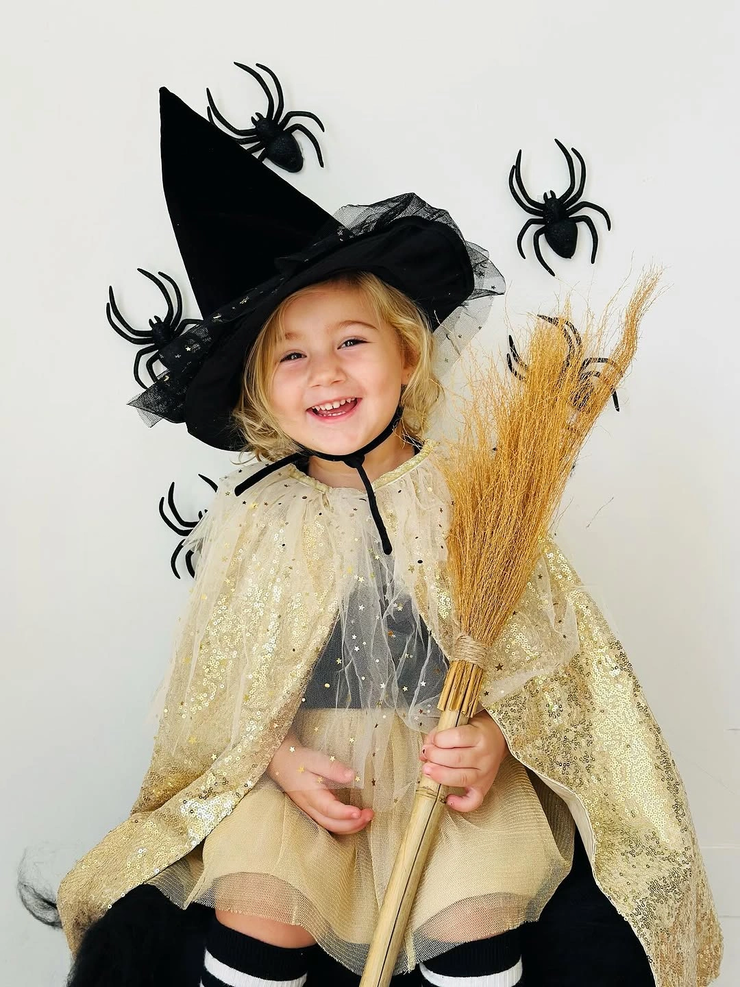 Kids witch costume with black pointed hat pale gold cape straw broom and dark boots